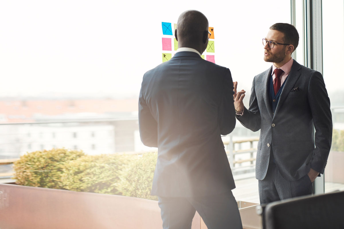 Two IT executives collaborating on a multi-location technology rollout strategy.