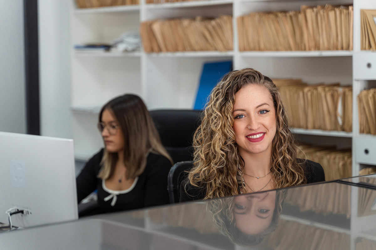 smiling dental or medical office manager at reception desk