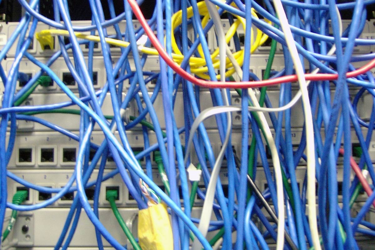 Messy, tangled network cabling in an equipment closet