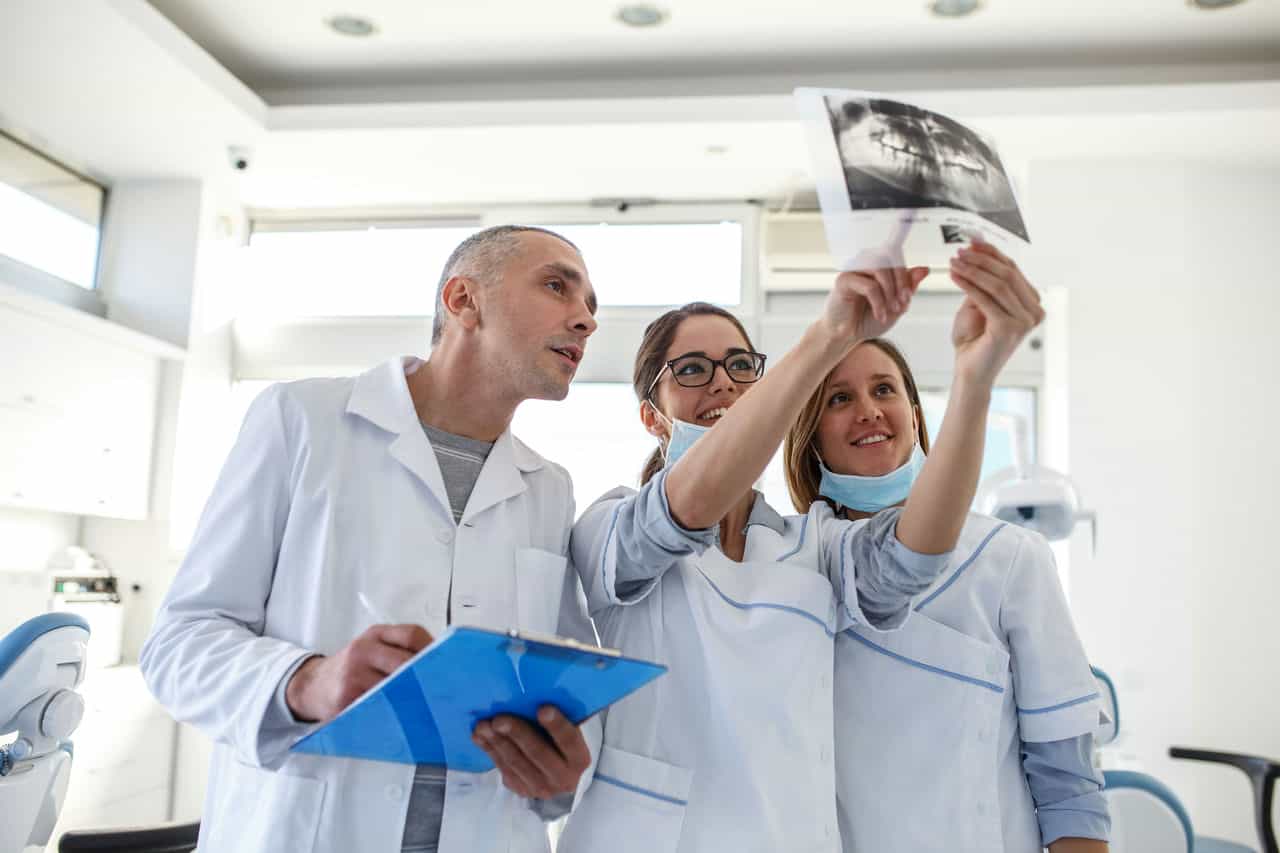 Group of dentists analyzing data from xray